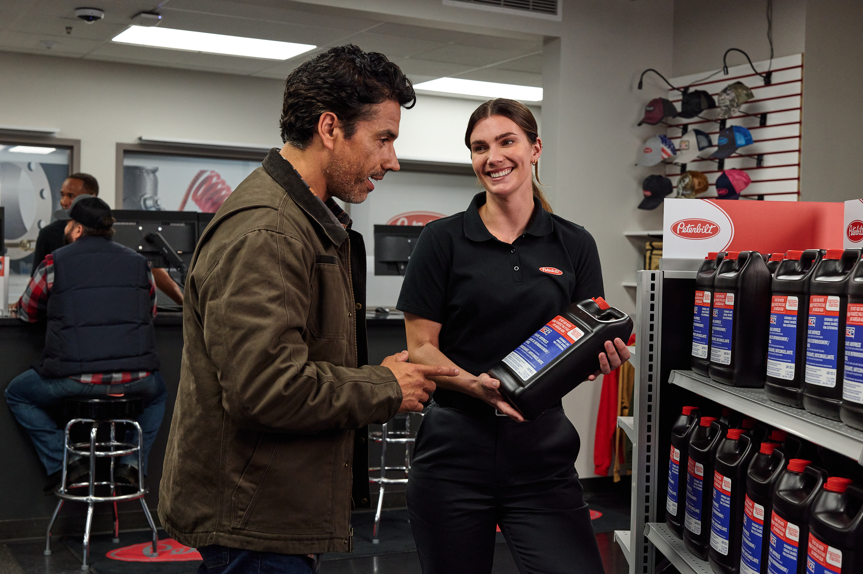 A Peterbilt clerk explains a part to a customer in a dealership